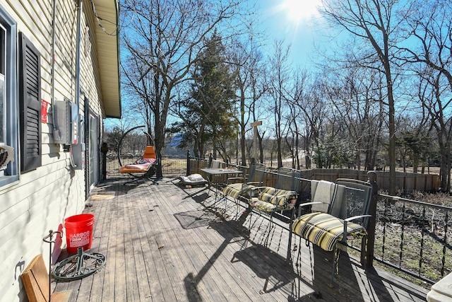 wooden terrace with a fenced backyard