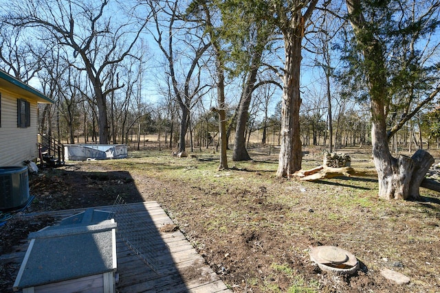 view of yard featuring a pool and central AC unit