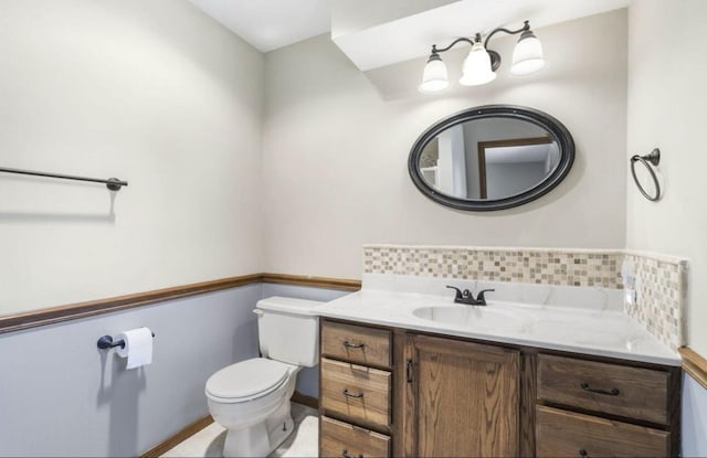 bathroom with toilet, backsplash, and vanity