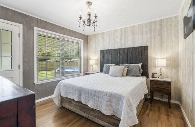 bedroom featuring dark wood-style floors, a chandelier, ornamental molding, and baseboards