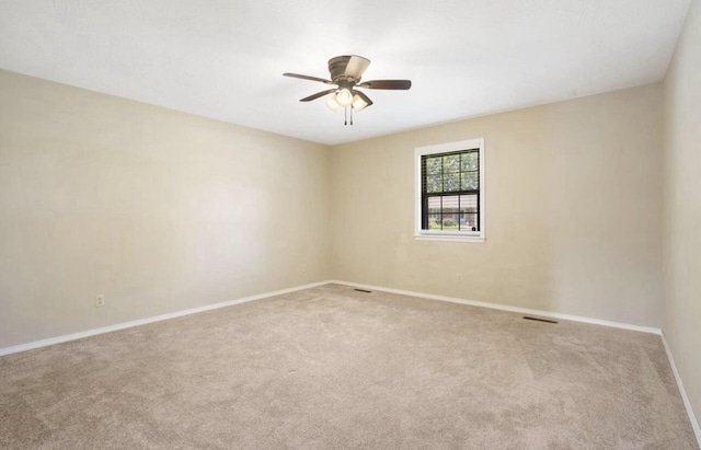 unfurnished room with visible vents, baseboards, a ceiling fan, and light colored carpet