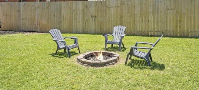 view of yard with fence and a fire pit