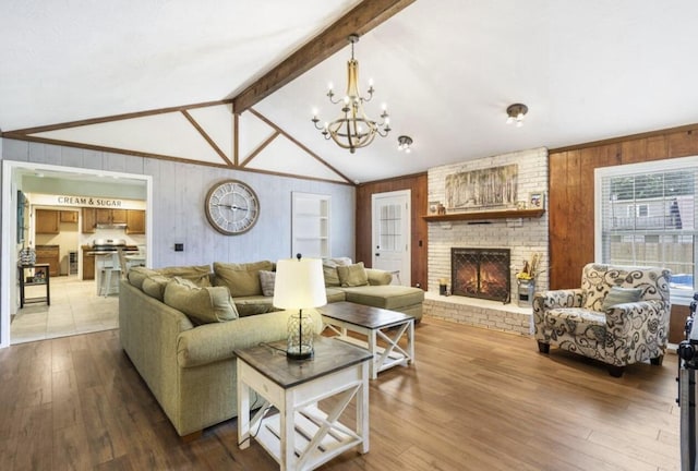 living area with wood walls, a fireplace, lofted ceiling with beams, and wood finished floors