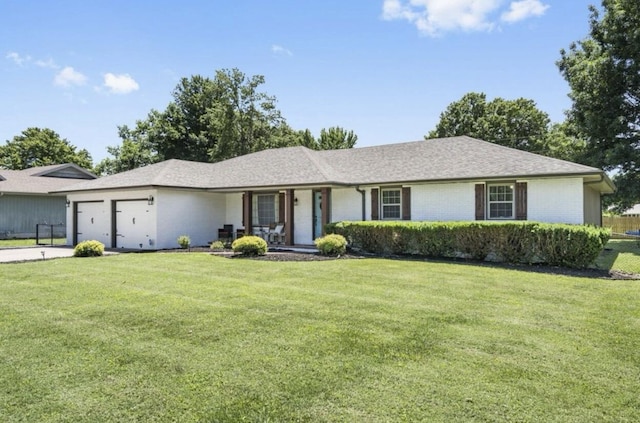 ranch-style home featuring a garage, a shingled roof, brick siding, concrete driveway, and a front lawn