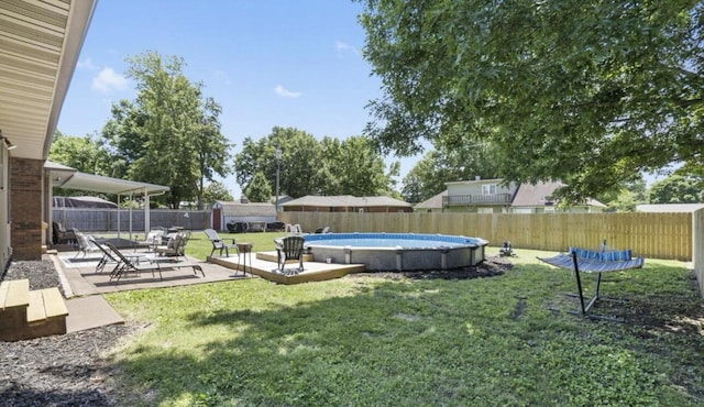 view of yard with a fenced backyard, a fenced in pool, and a patio