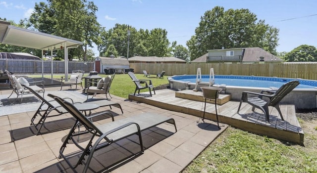 view of patio with a storage shed, a fenced backyard, a fenced in pool, and an outbuilding