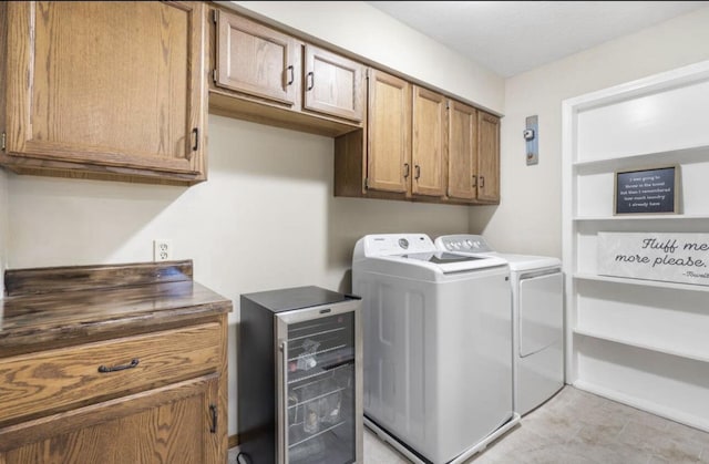 laundry area with beverage cooler, washer and clothes dryer, and cabinet space