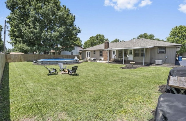 view of yard with a fenced in pool, entry steps, cooling unit, a fenced backyard, and a fire pit