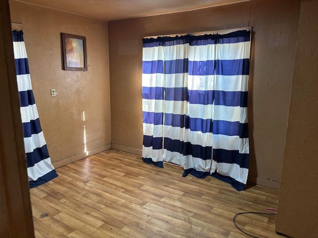 empty room with a textured wall and wood finished floors