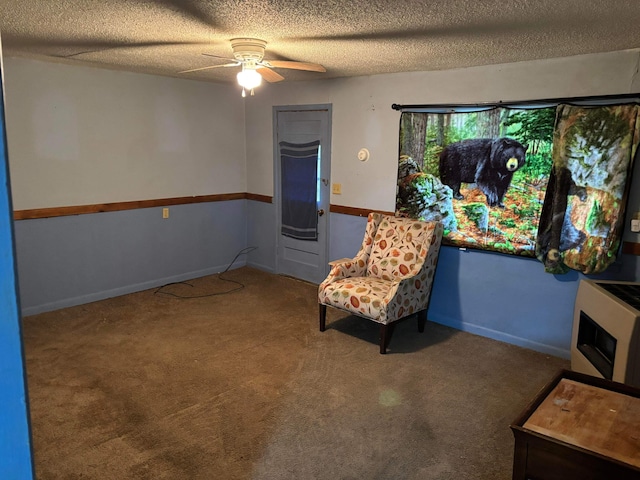 sitting room with a textured ceiling, carpet floors, ceiling fan, and baseboards