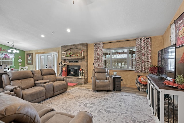 living area with light wood-style flooring, a chandelier, a textured ceiling, and recessed lighting