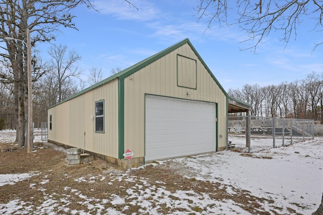 snow covered garage featuring a detached garage