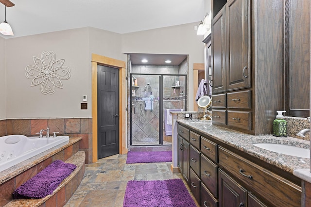 bathroom featuring double vanity, stone tile flooring, a sink, a shower stall, and a bath