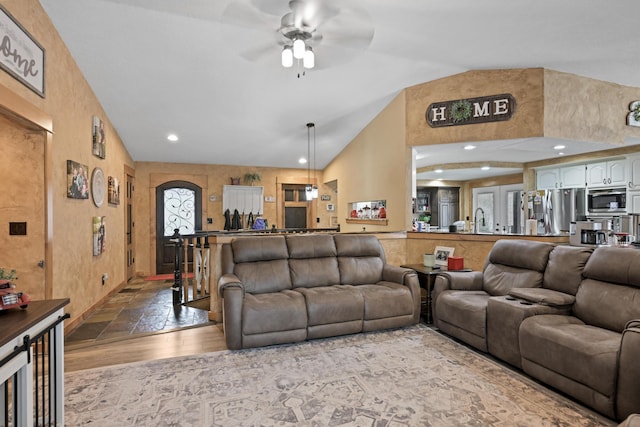 living room with arched walkways, a ceiling fan, lofted ceiling, wood finished floors, and recessed lighting