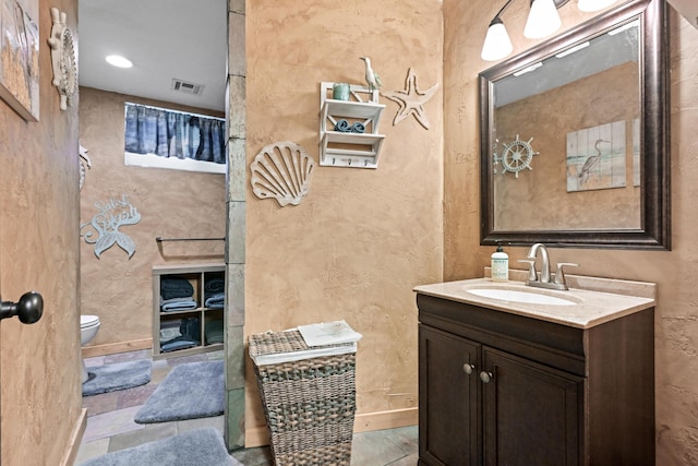 bathroom featuring toilet, visible vents, and vanity