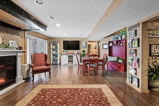 dining area featuring wood finish floors, a glass covered fireplace, and recessed lighting