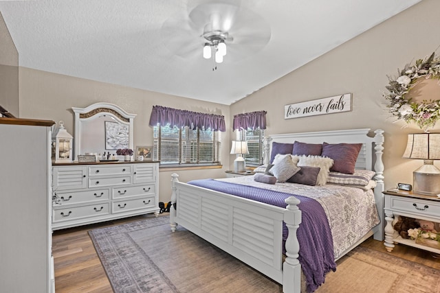 bedroom featuring ceiling fan, vaulted ceiling, and wood finished floors