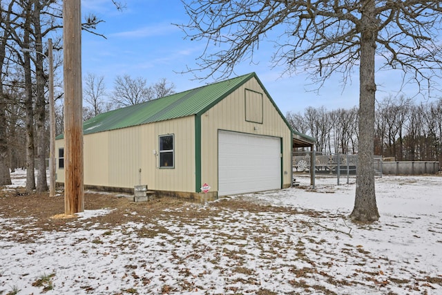 snow covered garage with a detached garage