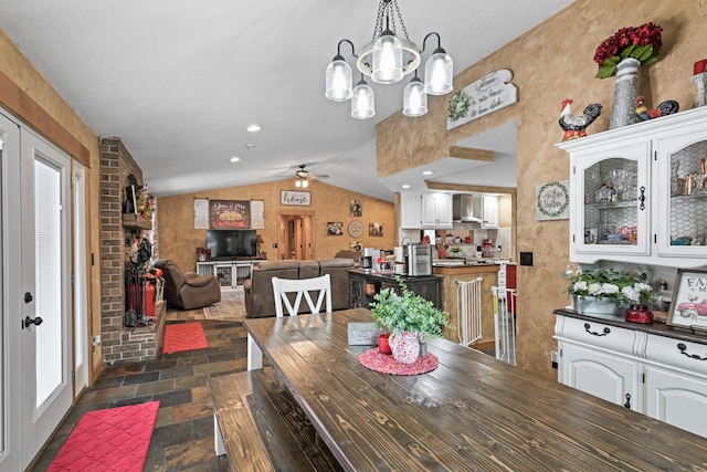 dining room featuring lofted ceiling, stone tile flooring, french doors, and recessed lighting