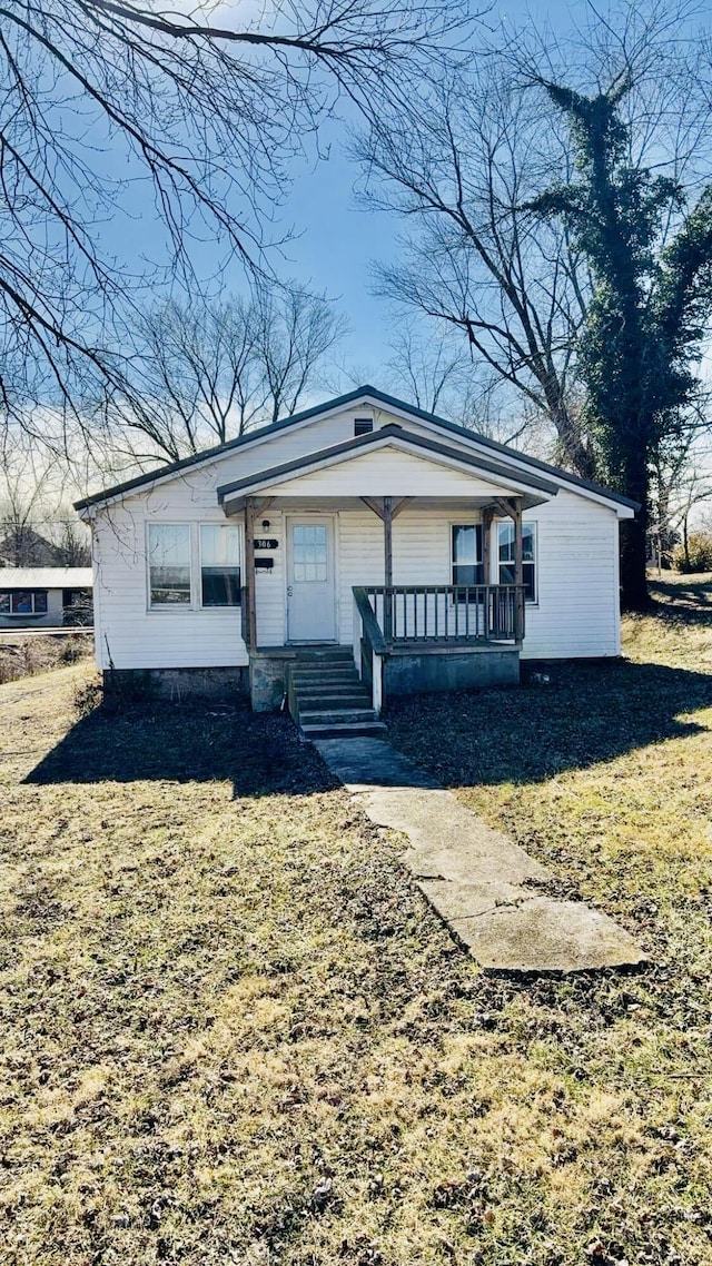 view of front of property featuring a front yard and covered porch