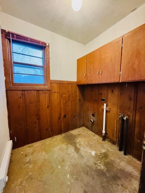 laundry room with wainscoting, cabinet space, and wooden walls