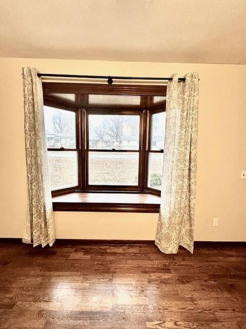 unfurnished room with dark wood-type flooring