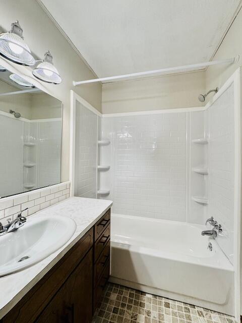 bathroom with shower / washtub combination, vanity, and tasteful backsplash