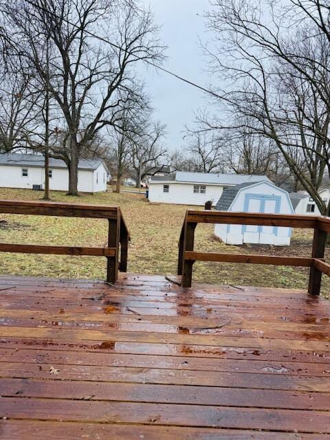 wooden deck with an outbuilding and a yard