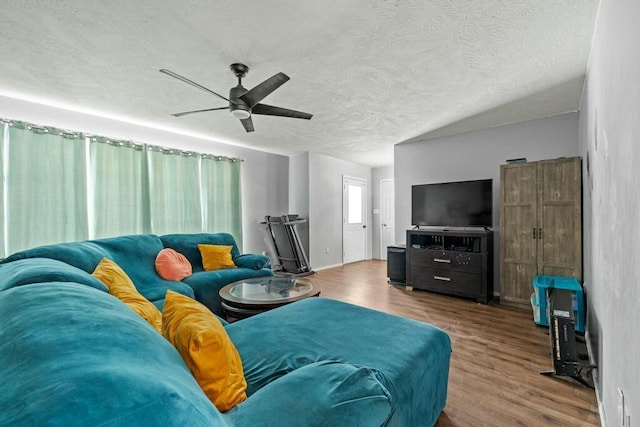 living room with ceiling fan, a textured ceiling, and wood finished floors