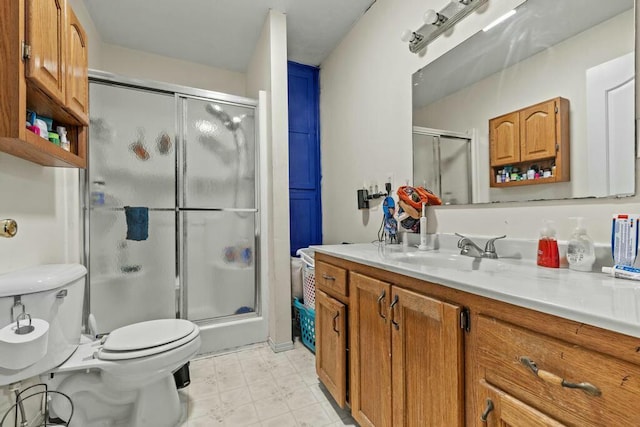 bathroom with toilet, a stall shower, and vanity