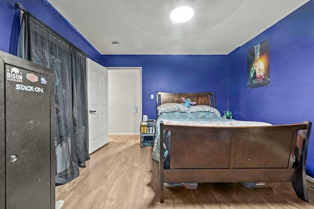 bedroom featuring light wood-type flooring and baseboards