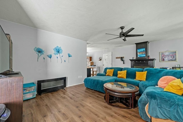 living room featuring a textured ceiling, ceiling fan, and wood finished floors