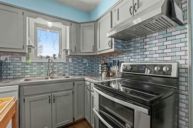 kitchen with gray cabinets, backsplash, a sink, double oven range, and exhaust hood