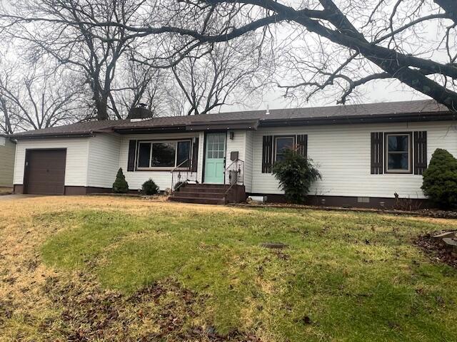 ranch-style house with a garage, driveway, and a front lawn