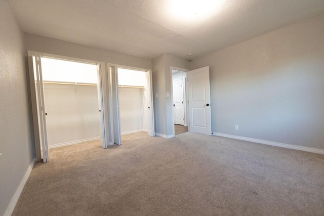 912 Armstrong Ave, West Plains, MO 65775 - unfurnished bedroom with light carpet, multiple closets, and baseboards