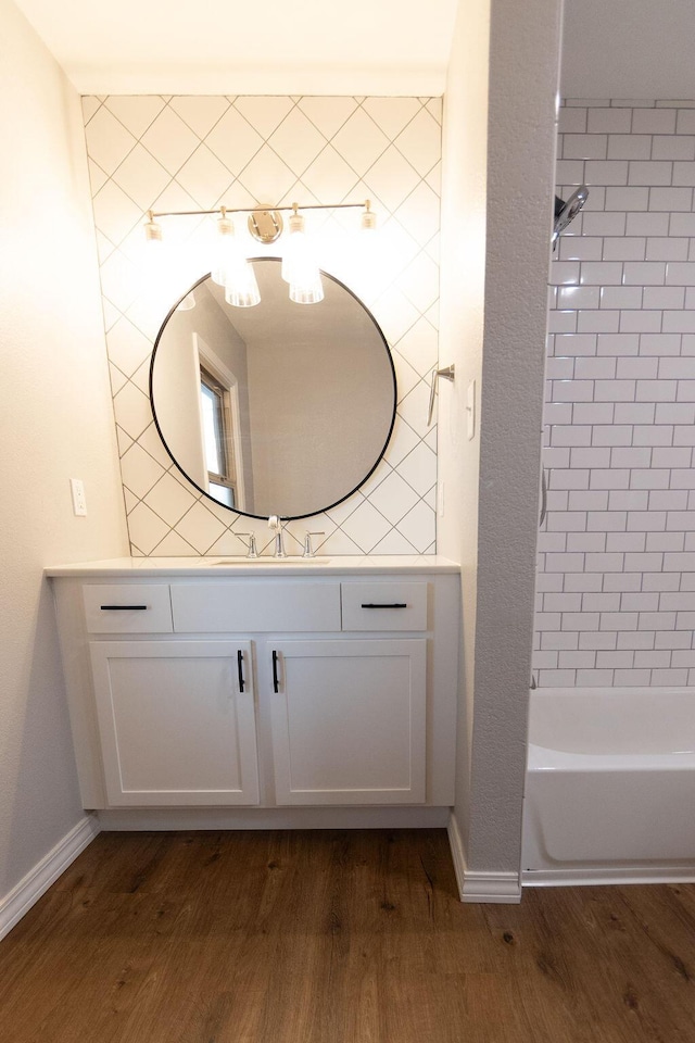 912 Armstrong Ave, West Plains, MO 65775 - full bathroom with baseboards, vanity, wood finished floors, and bathing tub / shower combination