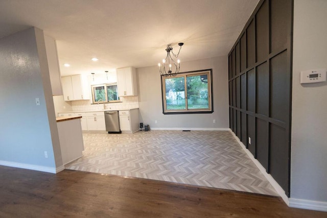 912 Armstrong Ave, West Plains, MO 65775 - kitchen with white cabinets, baseboards, a chandelier, decorative backsplash, and dishwasher