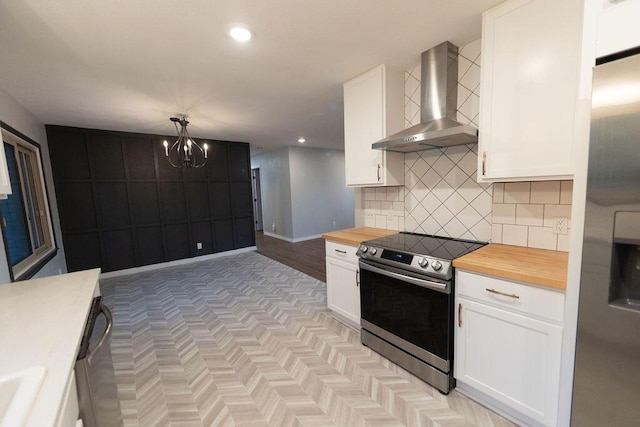 912 Armstrong Ave, West Plains, MO 65775 - kitchen with backsplash, butcher block counters, stainless steel appliances, white cabinets, and wall chimney exhaust hood