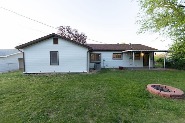912 Armstrong Ave, West Plains, MO 65775 - back of property featuring a fire pit, cooling unit, a patio area, and a lawn