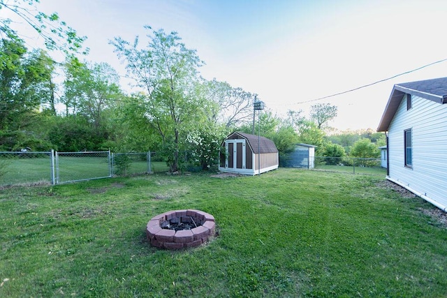 912 Armstrong Ave, West Plains, MO 65775 - view of yard with a storage unit, a fenced backyard, a fire pit, a gate, and an outdoor structure
