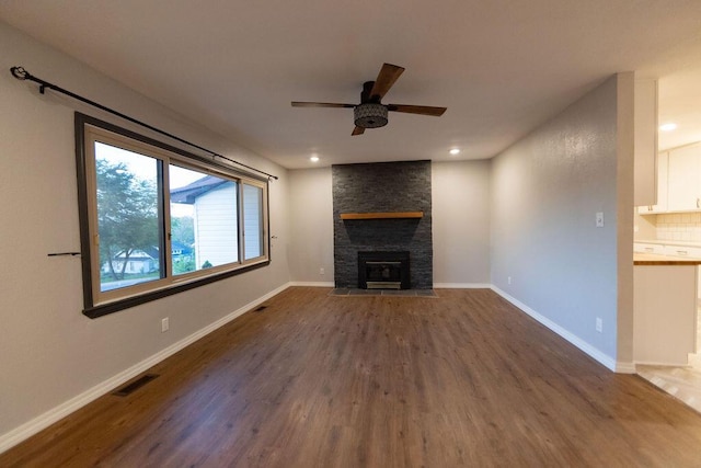912 Armstrong Ave, West Plains, MO 65775 - unfurnished living room featuring a ceiling fan, visible vents, a large fireplace, and dark wood-type flooring
