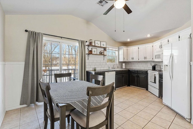 kitchen with dark countertops, visible vents, white cabinetry, a sink, and white appliances