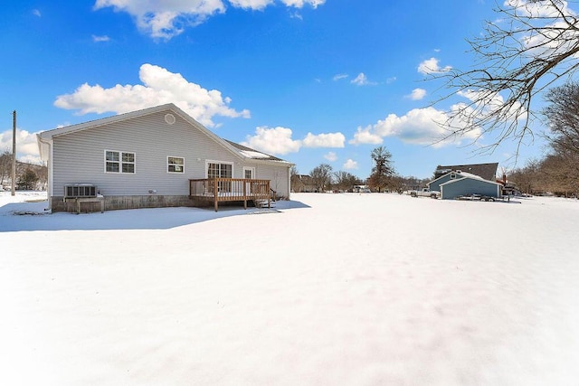 snow covered rear of property featuring a deck