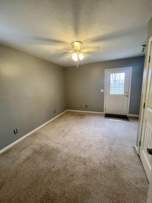 unfurnished room with carpet floors, baseboards, and a textured ceiling