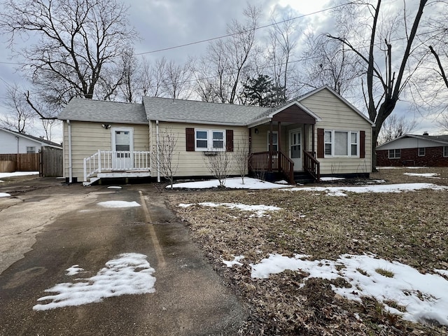 view of front of property with a shingled roof and driveway