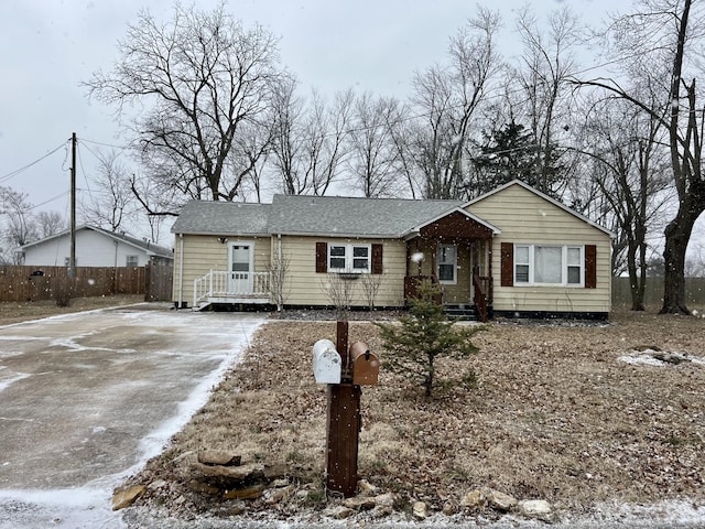 ranch-style house featuring driveway and fence