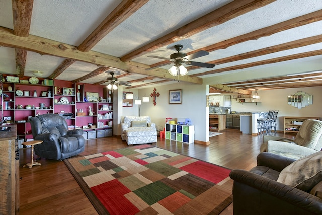 living area with a textured ceiling, beam ceiling, baseboards, and dark wood-style flooring