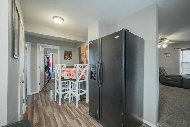 kitchen featuring black fridge, baseboards, and wood finished floors