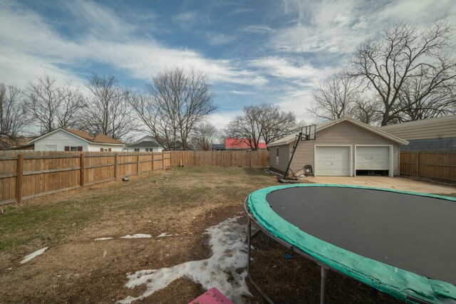 view of yard featuring an outbuilding, a trampoline, and a fenced backyard