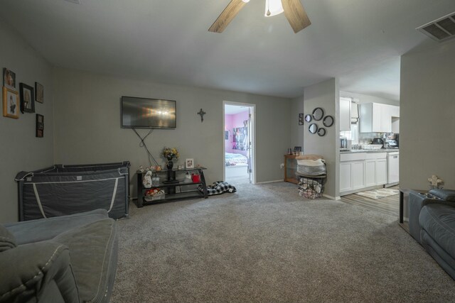living area featuring visible vents, light carpet, and a ceiling fan